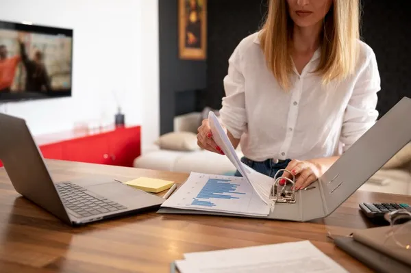 Femme travaillant sur des documents au bureau.