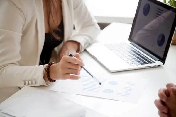Réunion d'affaires avec documents et ordinateur portable.
