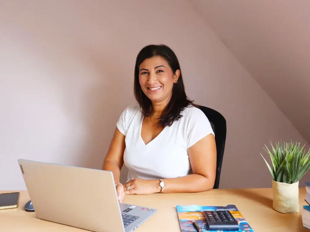 Sofia de l'équipe Ilyara souriante à son bureau devant son ordinateur